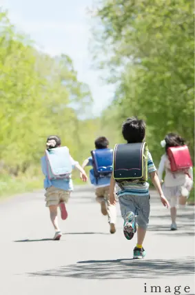 小学生の子供が楽しそうに学校に通学している
